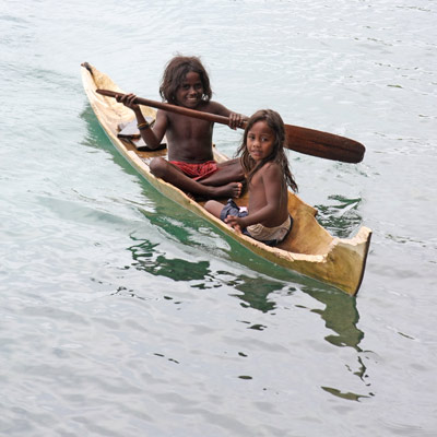 kids in a wooden canoe