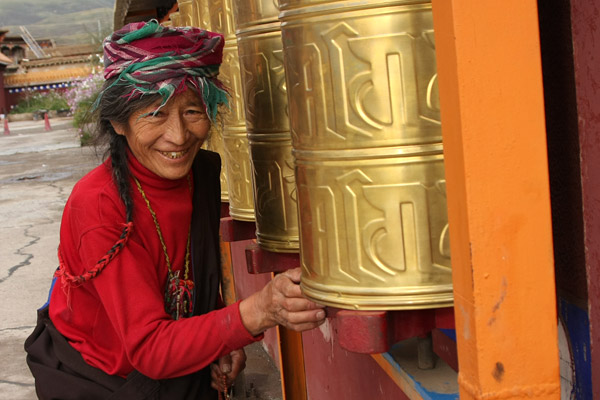 Old lady spinning prayer wheels